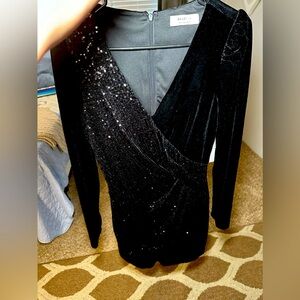 Black dress with sequels on one side. Short with long sleeves